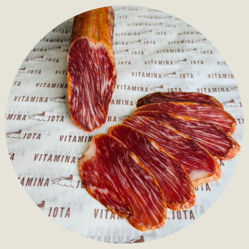 Caña de lomo ibérico cortada mostrando el veteado de grasa infiltrada